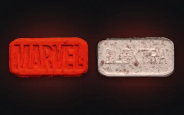 Czerwona tabletka MDMA Marvel z obu stron: logo MARVEL na jednej stronie, ELEKTRA na drugiej